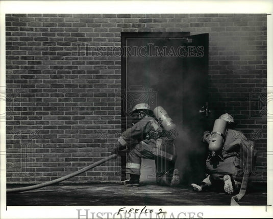 1991 Press Photo Cadets from Tri-C's Fire Training Academy open a door - Historic Images