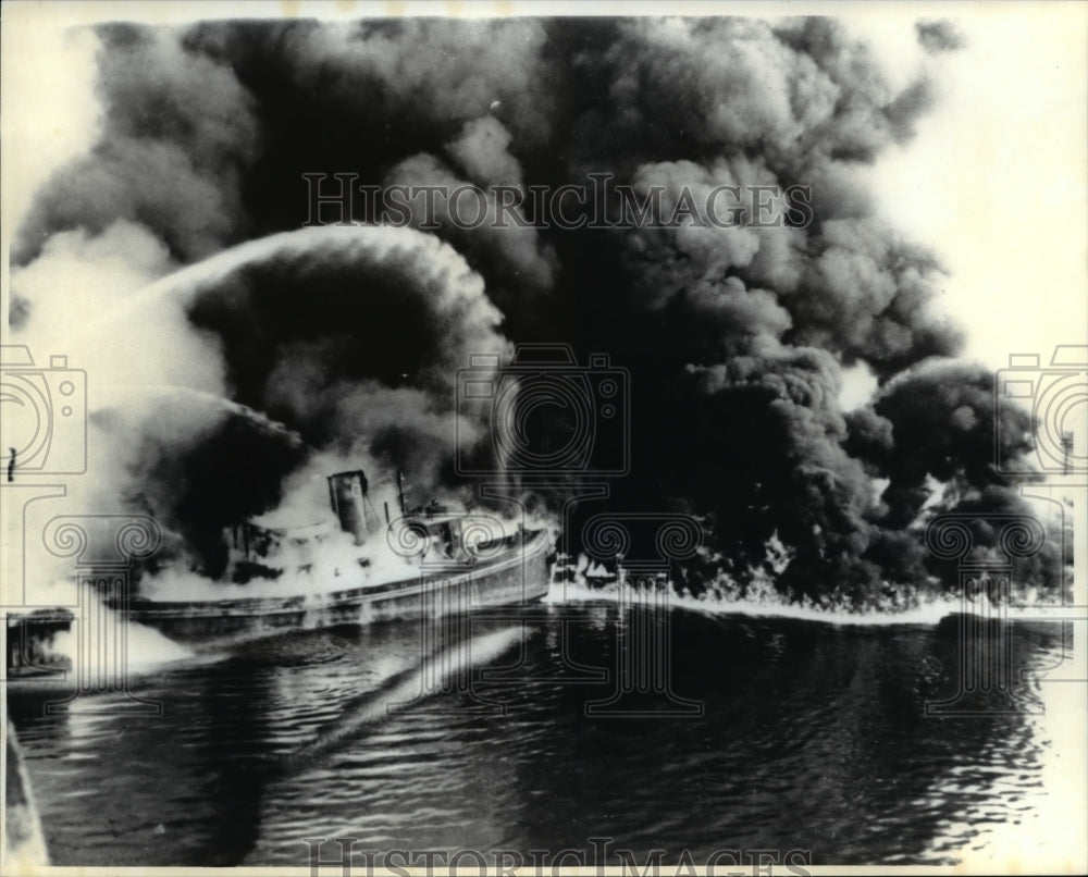 Ship on fire and flame being extinguished - Historic Images