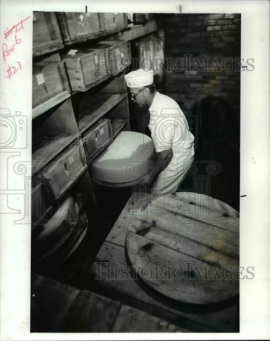1987 Press Photo Mickey Schimd flips a 400-pound wheel of Swiss cheese-Historic Images