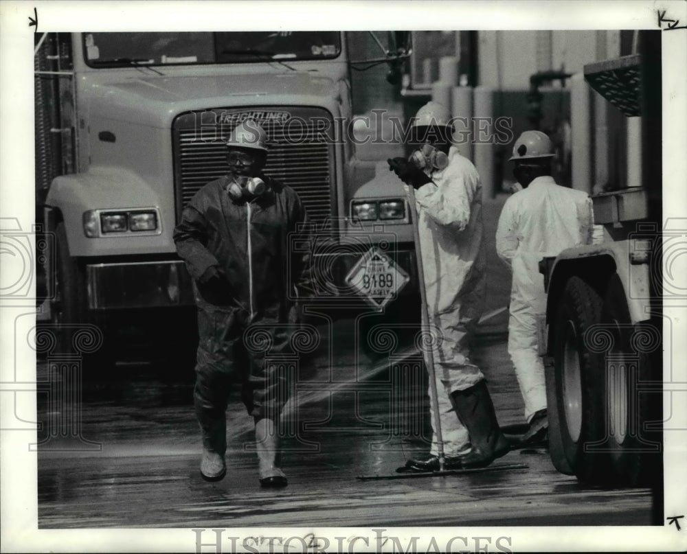 1990, Workers at GSX spray an area behind their plant - cva65740 - Historic Images