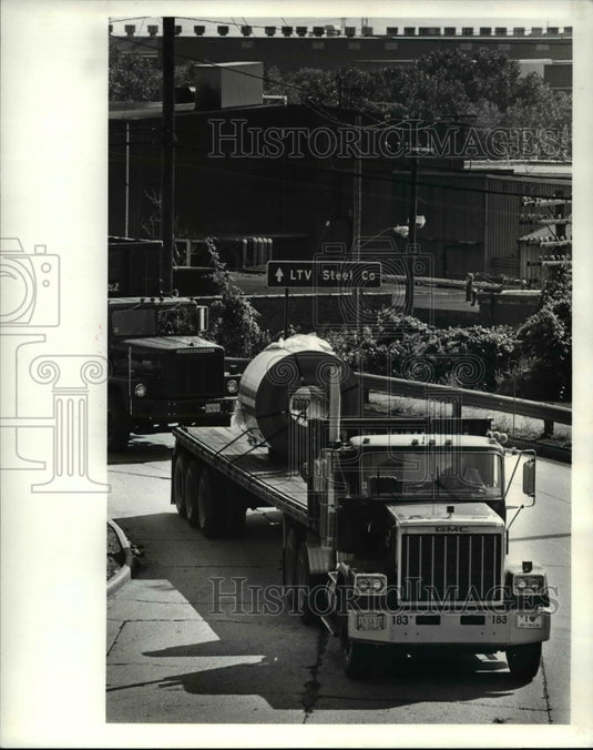 1986 Press Photo Flatbed semi-truck turns onto Jennings road from LTV steel - Historic Images