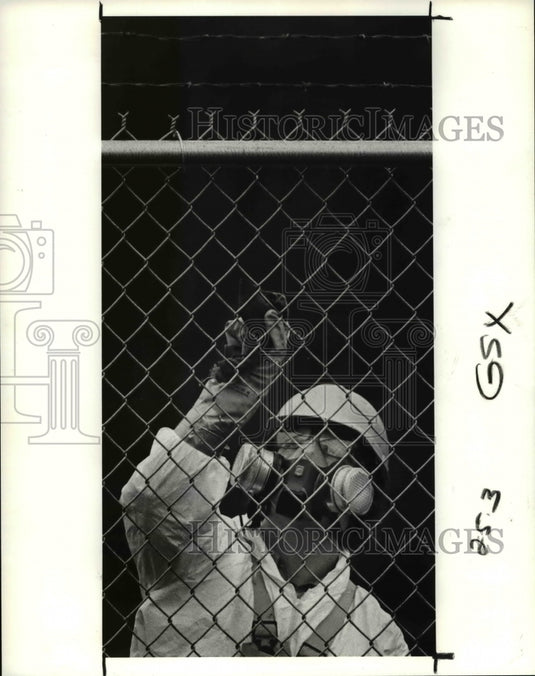 1990 Press Photo Worker cleans the fence at GSX at site of last week's spill - Historic Images