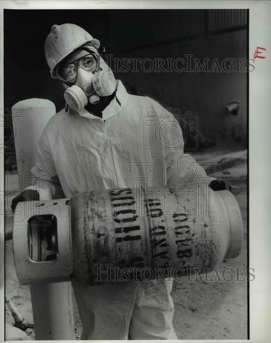 1989 Press Photo Donald Robinson, materials handler carries a tank of gas at GSX - Historic Images