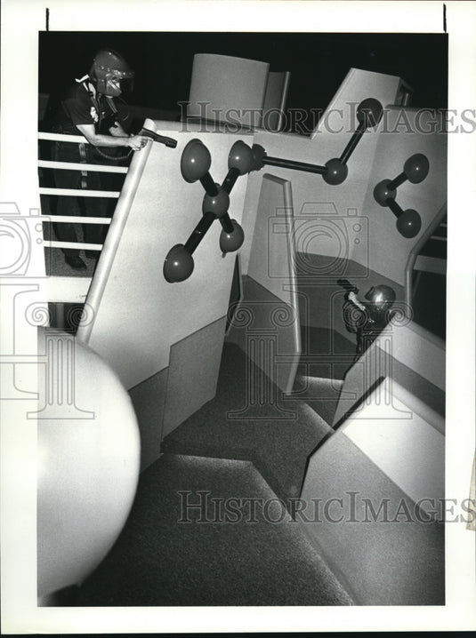 1986 Press Photo Manuel Saridakis takes aim at Camille Orndoff- Historic Images
