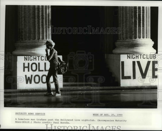 1990 Press Photo A homeless man trudges past the Hollywood Live nightclub - Historic Images
