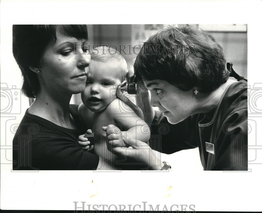 1983 Press Photo Nurse practioner Sarah Danner checks the ears of Caroline Moyer - Historic Images