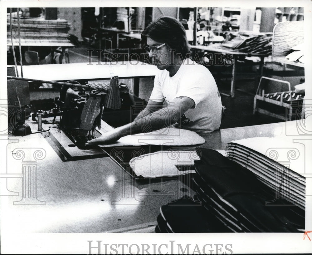 1977 Press Photo Theodore West sews material in General Motors Fisher Division - Historic Images