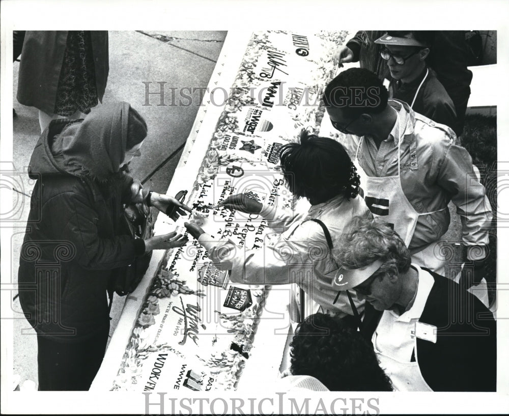 1987 Press Photo Jackie Hensel purchase first piece of cake from Sherry Carter - Historic Images