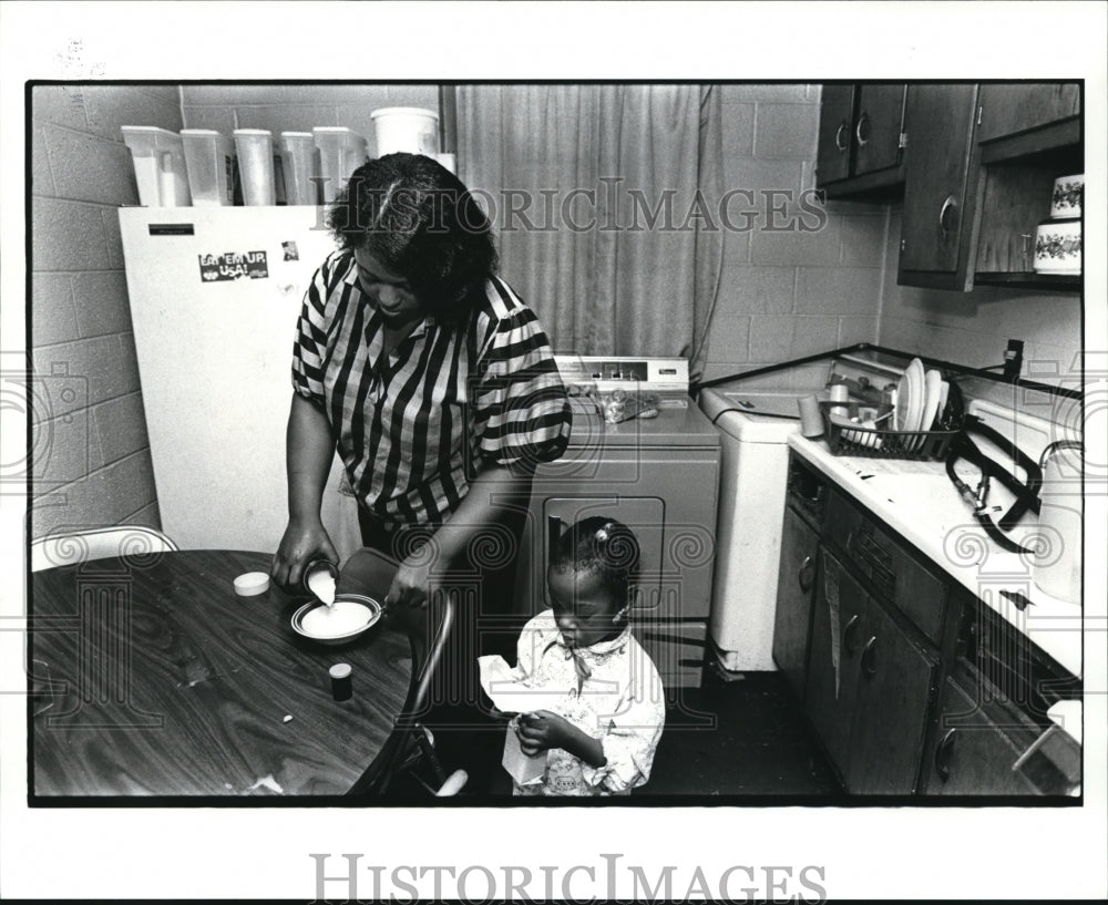 1986 Press Photo Anita Buffington prepares baby food as Daughter Latasha watch - Historic Images