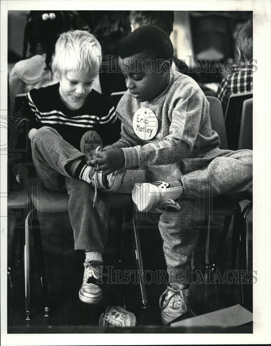 1988 Press Photo Eric Motley, helps Waylon Felty tie his shoes at the Shoes - Historic Images