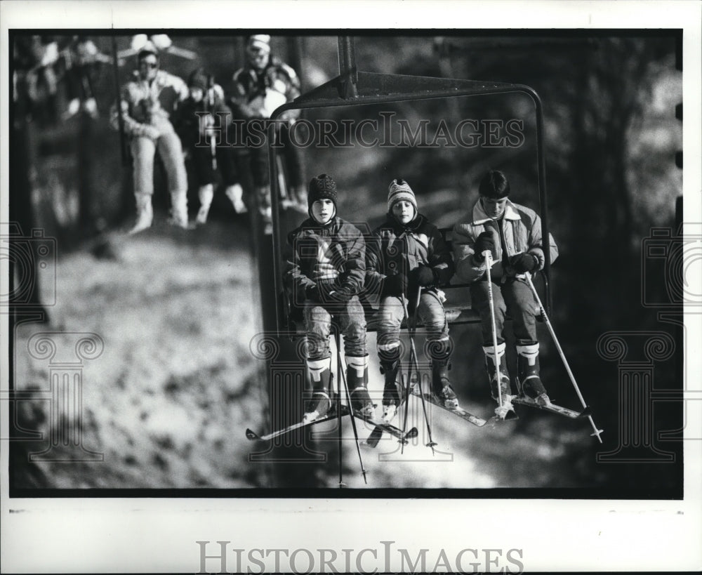 1989 Press Photo Skiers ride the chair lift at Boston Mills Ski Area - Historic Images