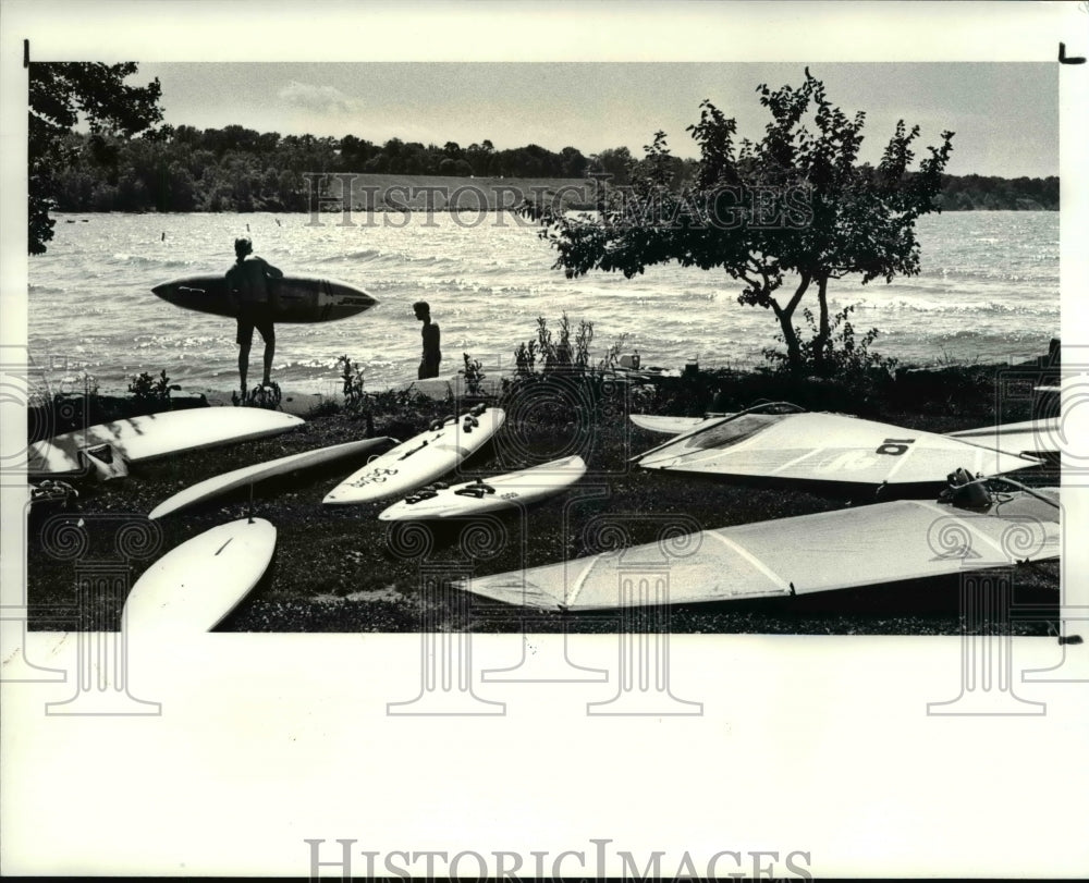 1987 Press Photo Clif Brennan carries his board into Lake Erie for Brian Davey - Historic Images