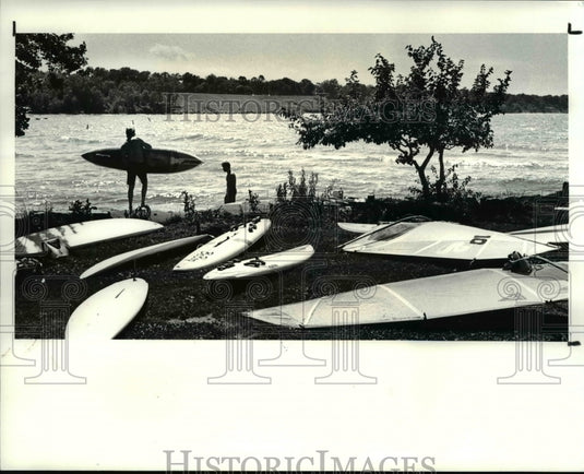 1987 Press Photo Clif Brennan carries his board into Lake Erie for Brian Davey - Historic Images