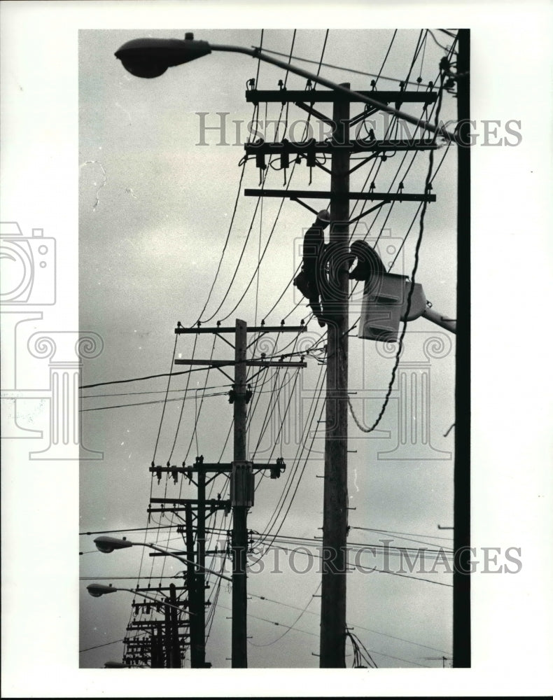 1987 Press Photo Linemen work the poles along Woodhill Road and East 93rd St. - Historic Images