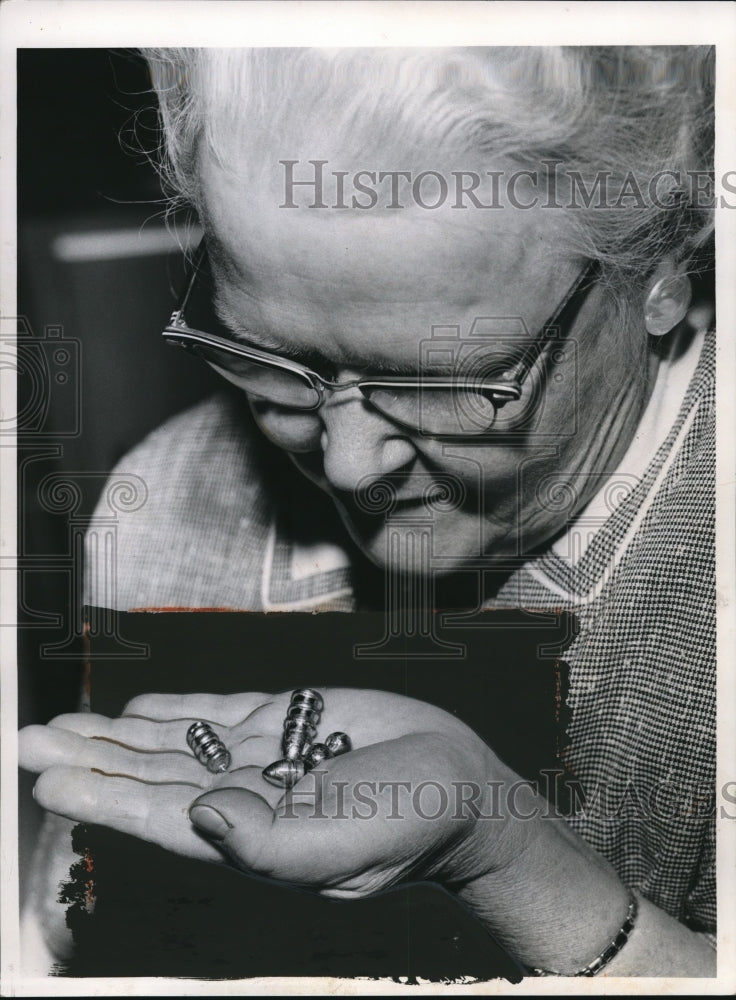 1961 Mrs Ralph Benivs, museum specialist, with Civil War bullets - Historic Images