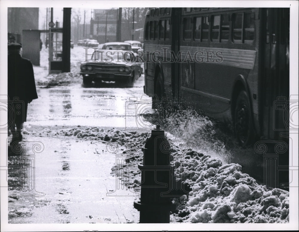 1962 Press Photo Snow Weather at E79th Euclid. Pedestrian gets Splashed. - Historic Images