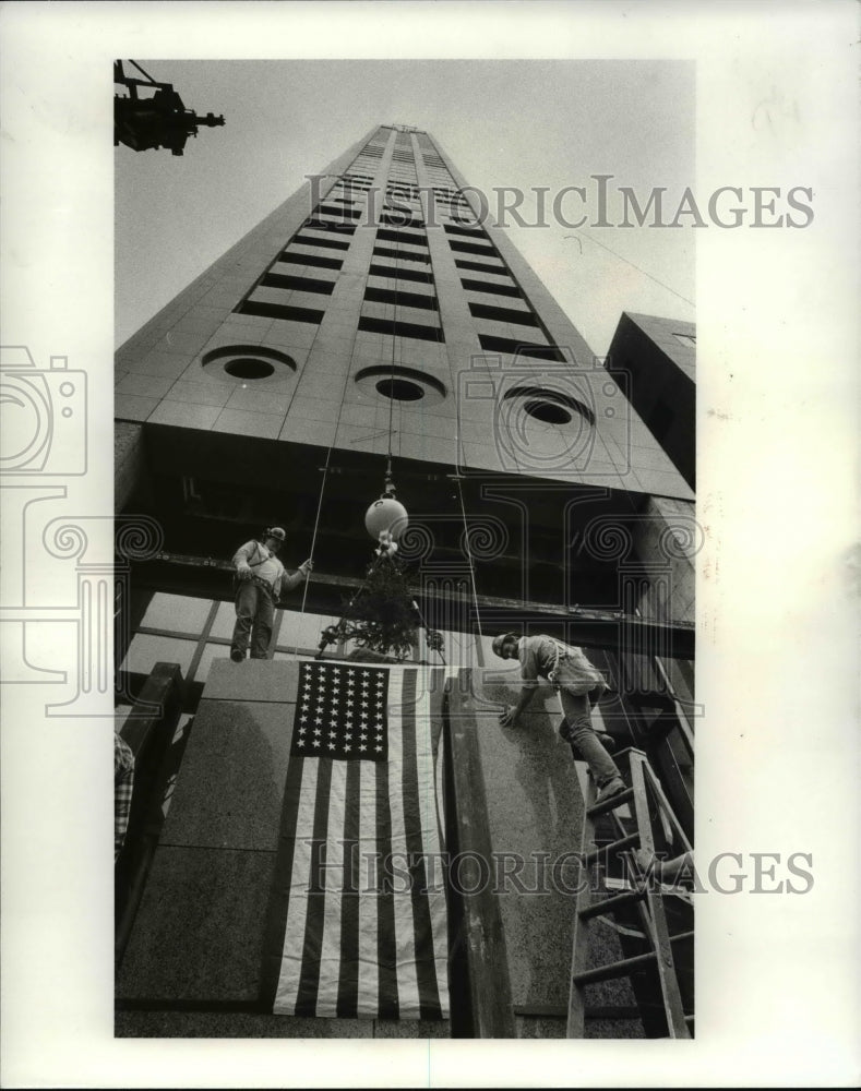 1985 Press Photo Shamus Rudy and Ron Cantor, iron workers ready the flag - Historic Images