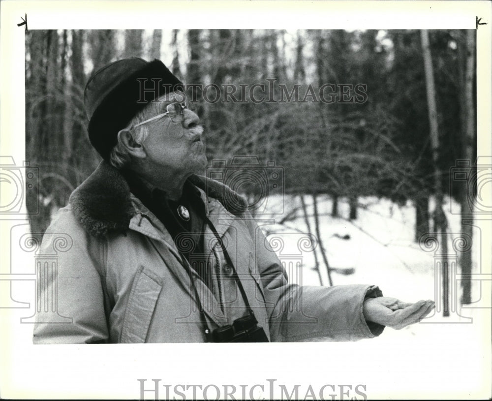 1984 Press Photo Harold Wallin coaxes a friend to eat from his hand - Historic Images