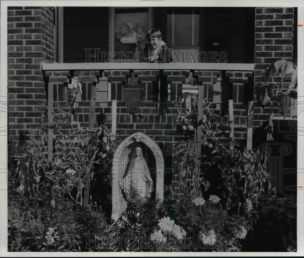 1977 Press Photo Frank Lamont Jr front yard home, 1927 E 120th St with flowers - Historic Images