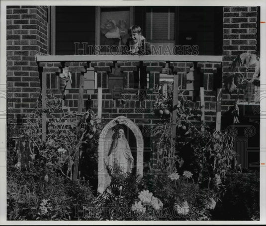 1977 Press Photo Frank Lamont Jr front yard home, 1927 E 120th St with flowers - Historic Images