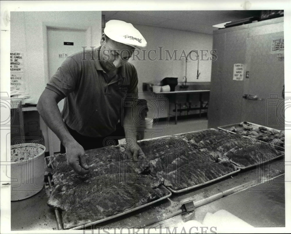 1986 Press Photo Putting bread crumbs and seasoning on ribs before grilling - Historic Images