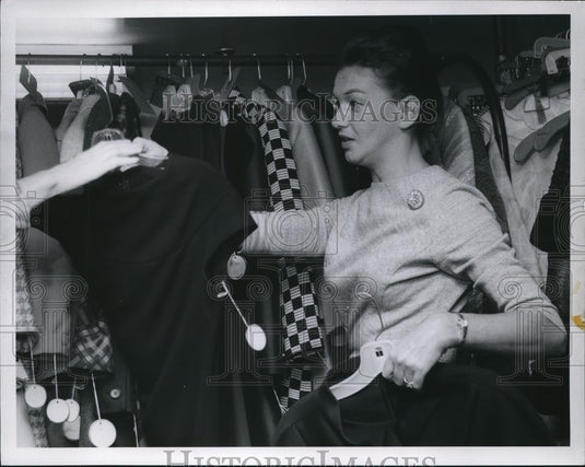 1966 Press Photo Employee fixing clothe's display on the rack at Halle Bros. CO. - Historic Images