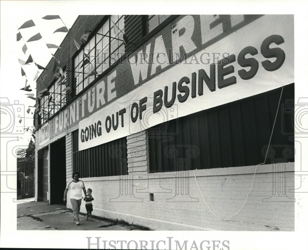 1984 Press Photo Jerry Gay and his son walked by Alpert Furniture Store. - Historic Images