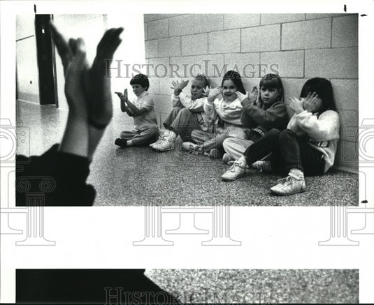 1989 Press Photo J.Perch Uses Hand in Butterfly Sign to Kids at Gurney Elem Sch. - Historic Images