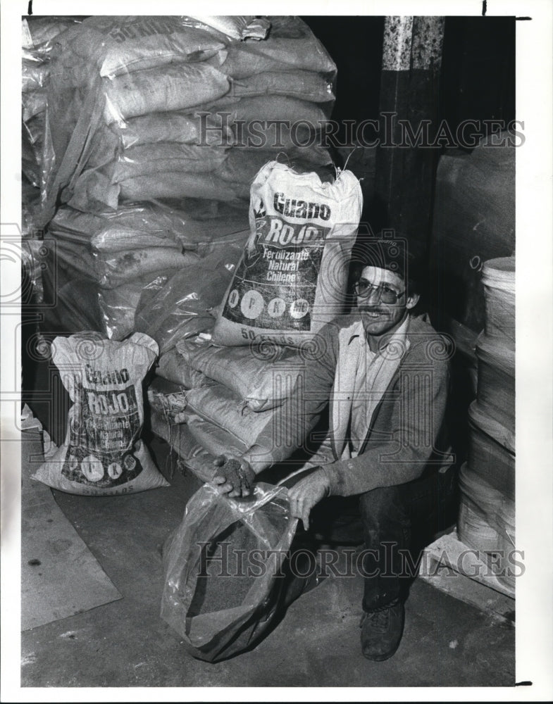 1989 Press Photo Larry Pozarelli packaging Guano in his warehouse. - Historic Images