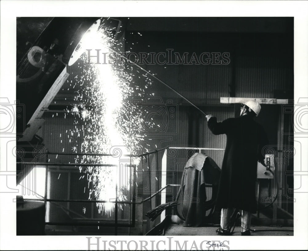 1986 Press Photo Jake McManir uses 02 prove to clean out the pouring hold - Historic Images