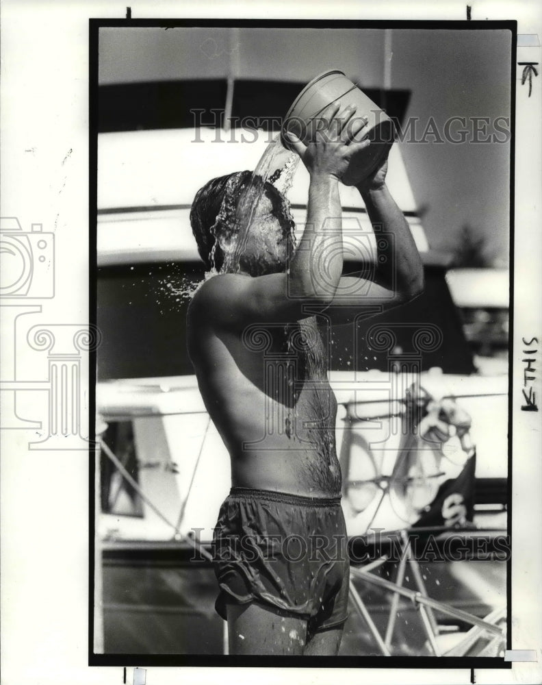 1991 Press Photo Gentleman cools off with bucket of water trying to cool down - Historic Images