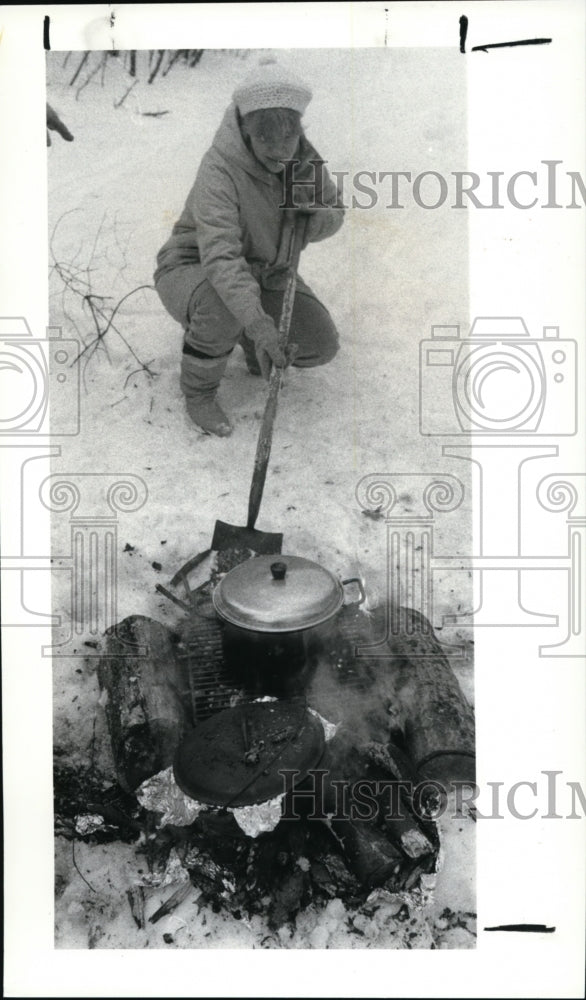 1987 Press Photo Palm Stonebraker keeps watch over cook fire at Girl Scouts - Historic Images