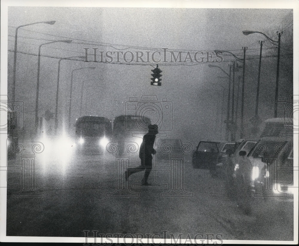 1977 Press Photo Man crossing the street at St. Clair Ave NE &amp; Ontario St. - Historic Images