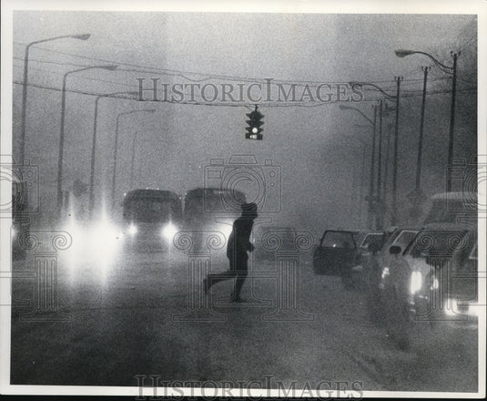 1977 Press Photo Man crossing the street at St. Clair Ave NE & Ontario St. - Historic Images