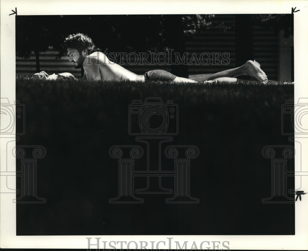 1984 Press Photo Brad Douglas take in the sunny weather time to study - Historic Images