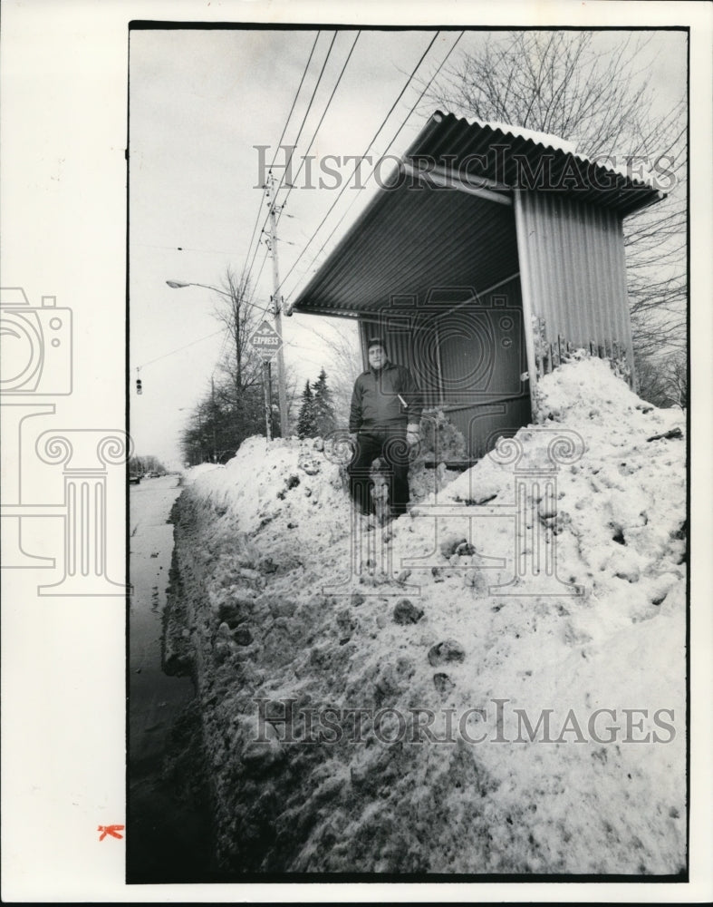 1977 Press Photo Henry Franz waits amid snowdrifts for bus along Mayfield - Historic Images