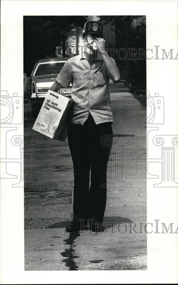 1983 Press Photo Joseph Mason wipes the sweat off his brow after buying a fan - Historic Images