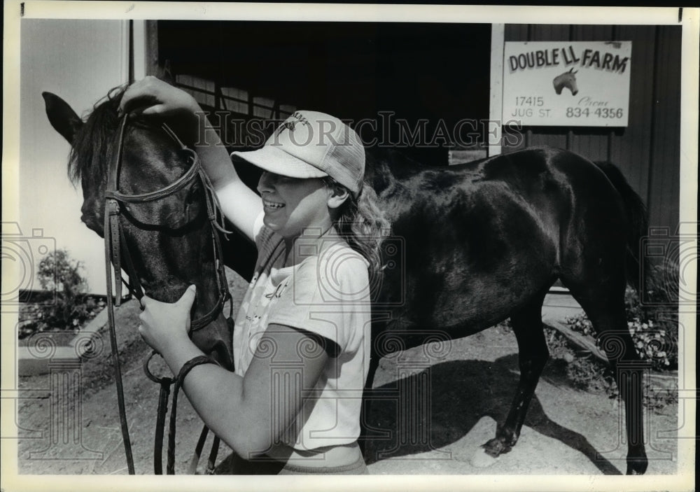 1986 Press Photo Kathy Kolesar removes harness from horse, 'Lealad' - cvb23083 - Historic Images