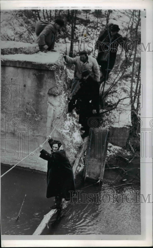 1957, Hungarian refugees cross canal using tree limb and guide line - Historic Images