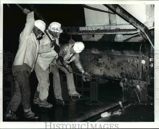 1986 Press Photo: C&H employees hook a metal boar on back of "supertruck" - Historic Images