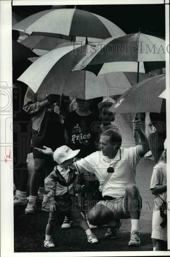 1991 Press Photo Ernie Poutty of Cuyahoga Falls and son Ernie,3 check for rain. - Historic Images