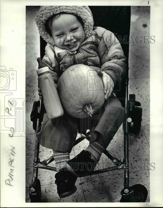 1986 Press Photo Wayne Hess Jr holds bottle & pumpkin, Near West Neighbors, Ohio - Historic Images