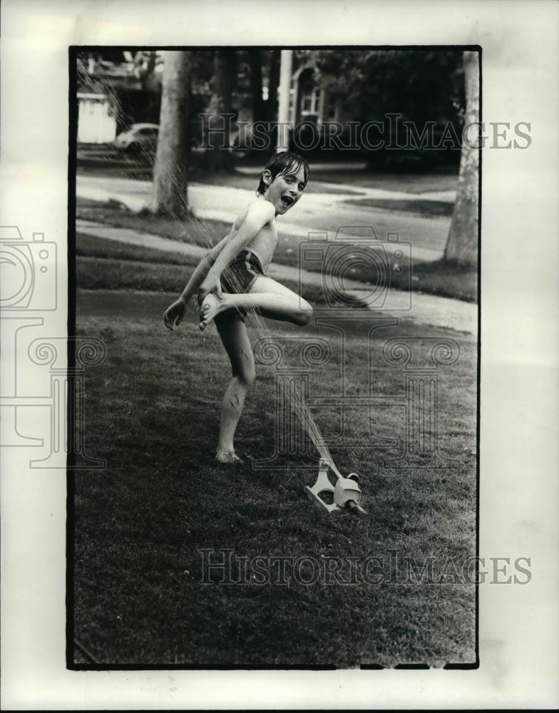 1982 Press Photo Aaron Hlebak of Lakewood, cools off. He is 7 years old - Historic Images