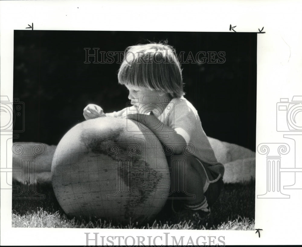 1986, Little Joe Sass play with globe ball at Children's Peace Fair - Historic Images