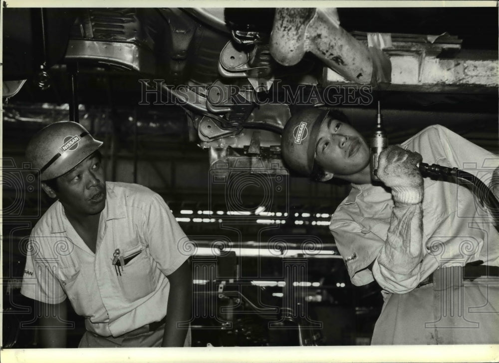 1984 Press Photo Teruo Suzuki works with an unidentified co-worker - cvb30316 - Historic Images