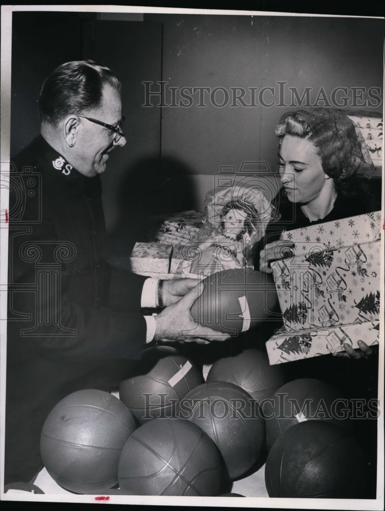 1964, Brig. Paul Hoffman passes out toys to Mrs. Ida Weston - Historic Images