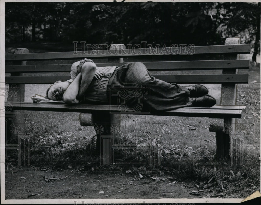 1947 Press Photo Man sleeps on a bench at the park - cvb33725-Historic Images