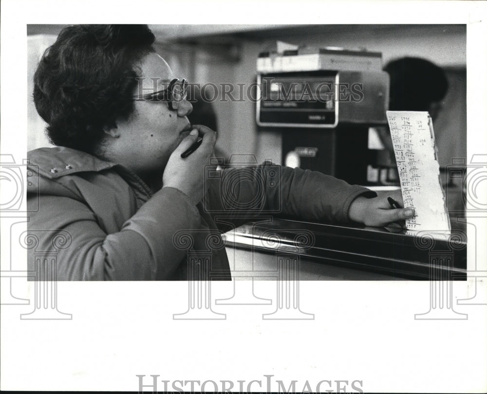 1985 Press Photo Food stamp shopper ponders the total sales she orders - Historic Images