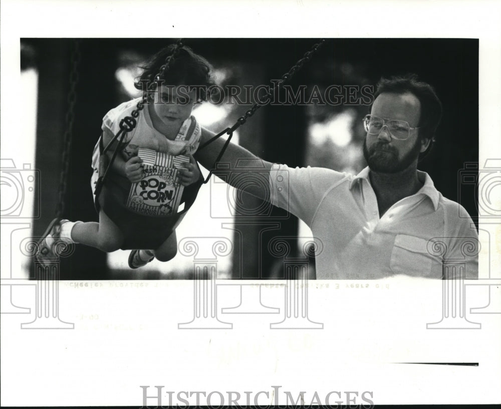 1990 Press Photo Jim McNeeley provides the push power for daughter Chafika - Historic Images