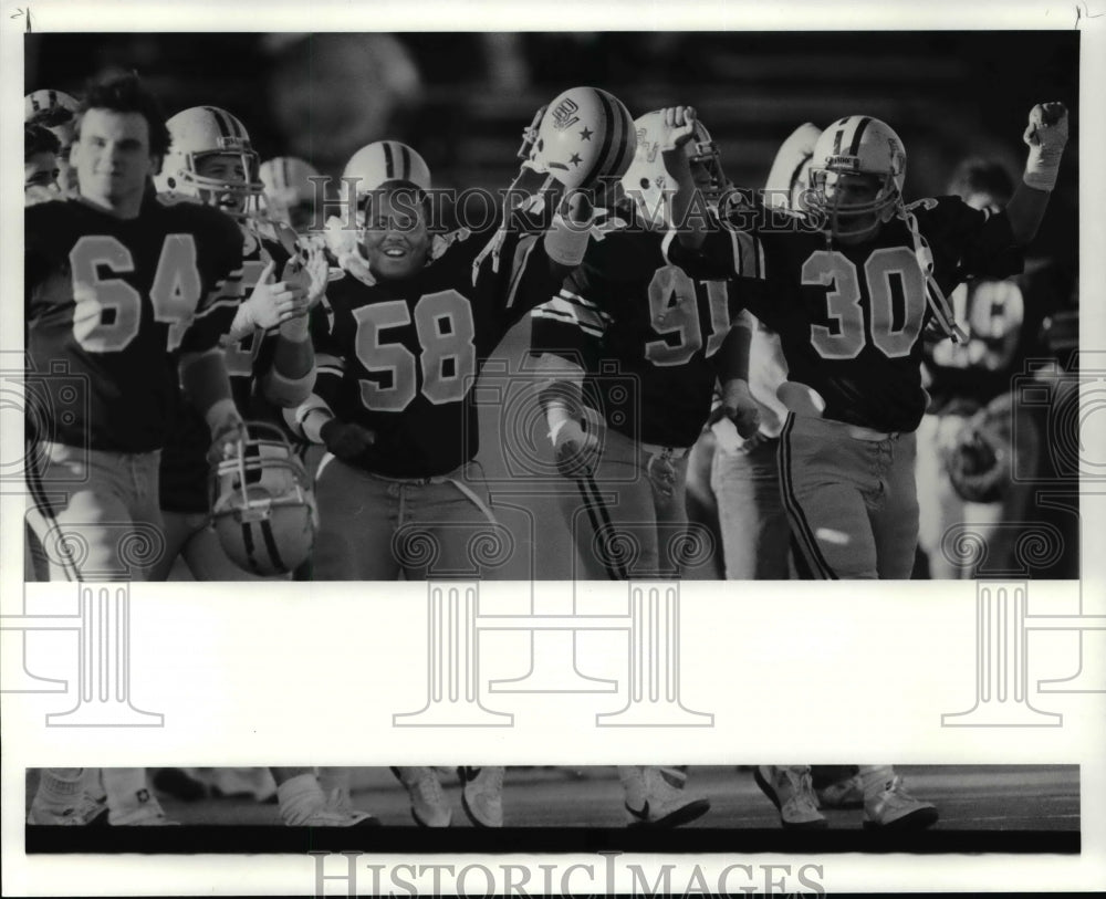 1985 Press Photo Baldwin Wallace team members run onto the field after their win - Historic Images